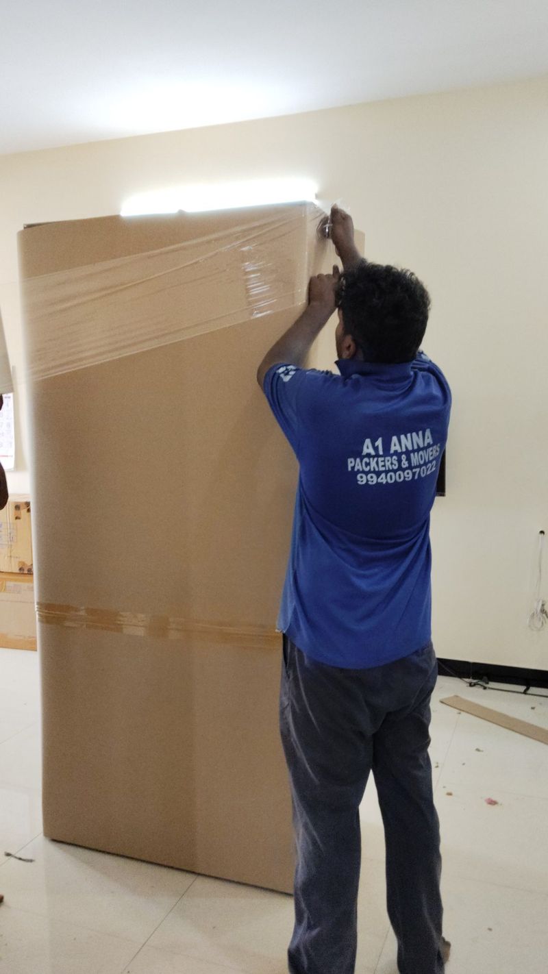 A1 Anna Packers and Movers crew member wrapping a wardrobe during a Coimbatore house shifting job