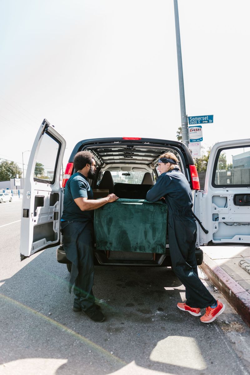 Movers loading office furniture into a van during an office relocation